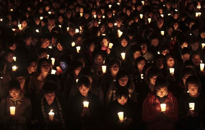 图为家长们聚集在佛寺,点烛祈祷孩子们大学入学考试取得成功.