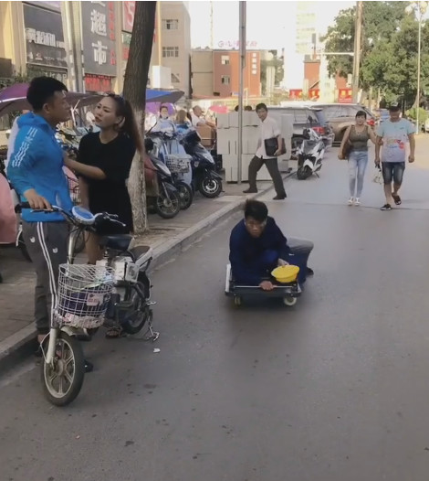 残疾乞丐坐着滑行车沿街乞讨,却被一对吵架的情侣意外揭穿了骗局