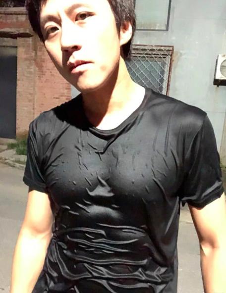 照片里的邓超身穿黑色t恤,上衣全部湿透,衣服贴在身上显露出腹肌和